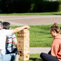 Students playing Jenga and stacking blocks on Kirkhof Lawn.